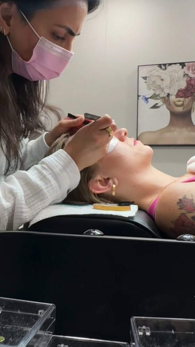 Minoo applying lash extensions to a client